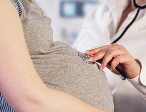 Médico examina mulher para prevenir arritmia na gravidez