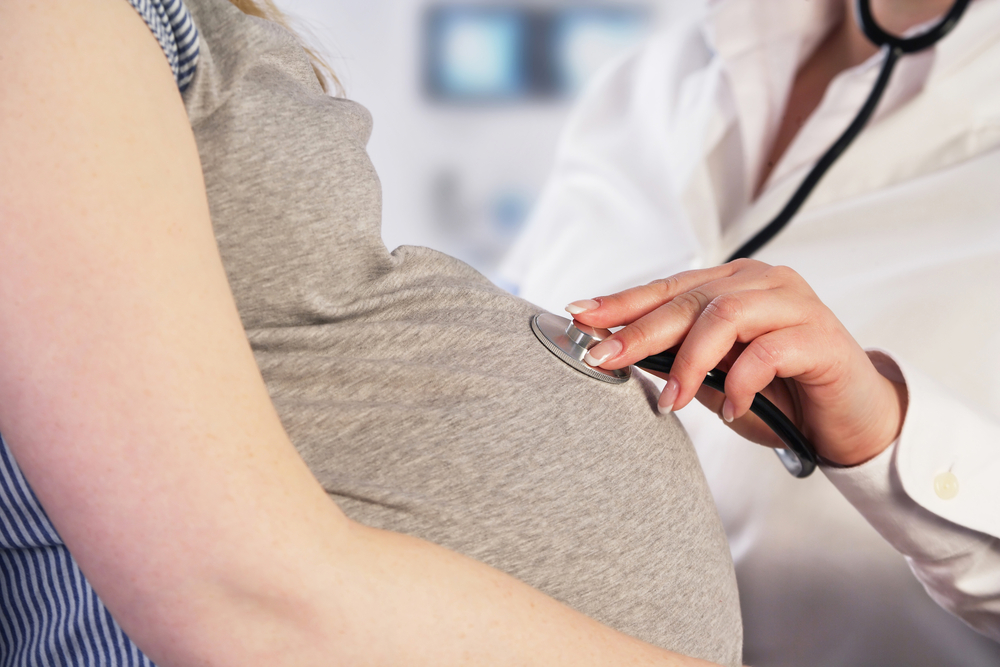 Médico examina mulher para prevenir arritmia na gravidez